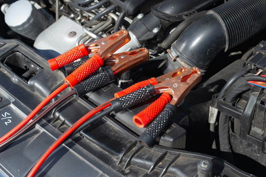 Jumper cables connected to a car battery at 7 Force Garage Sheffield, England. Car battery jump start service.
