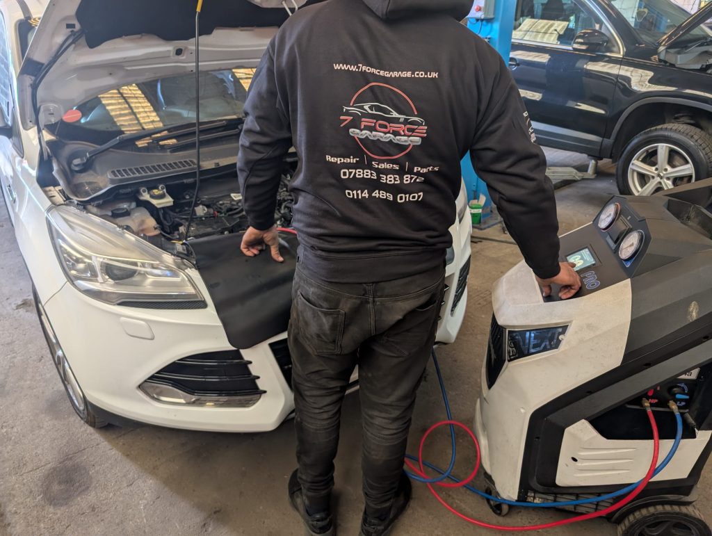 Mechanic servicing a car's air conditioning system 7 Force Garage Sheffield.